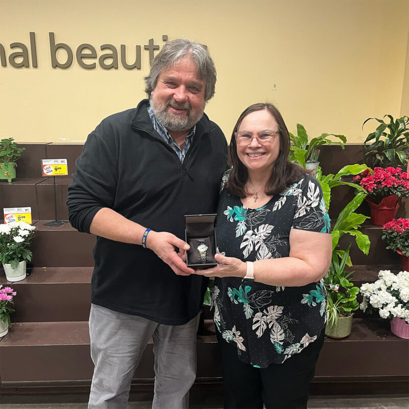 Rick Schneider presents Anita De Pew with her retirement watch.